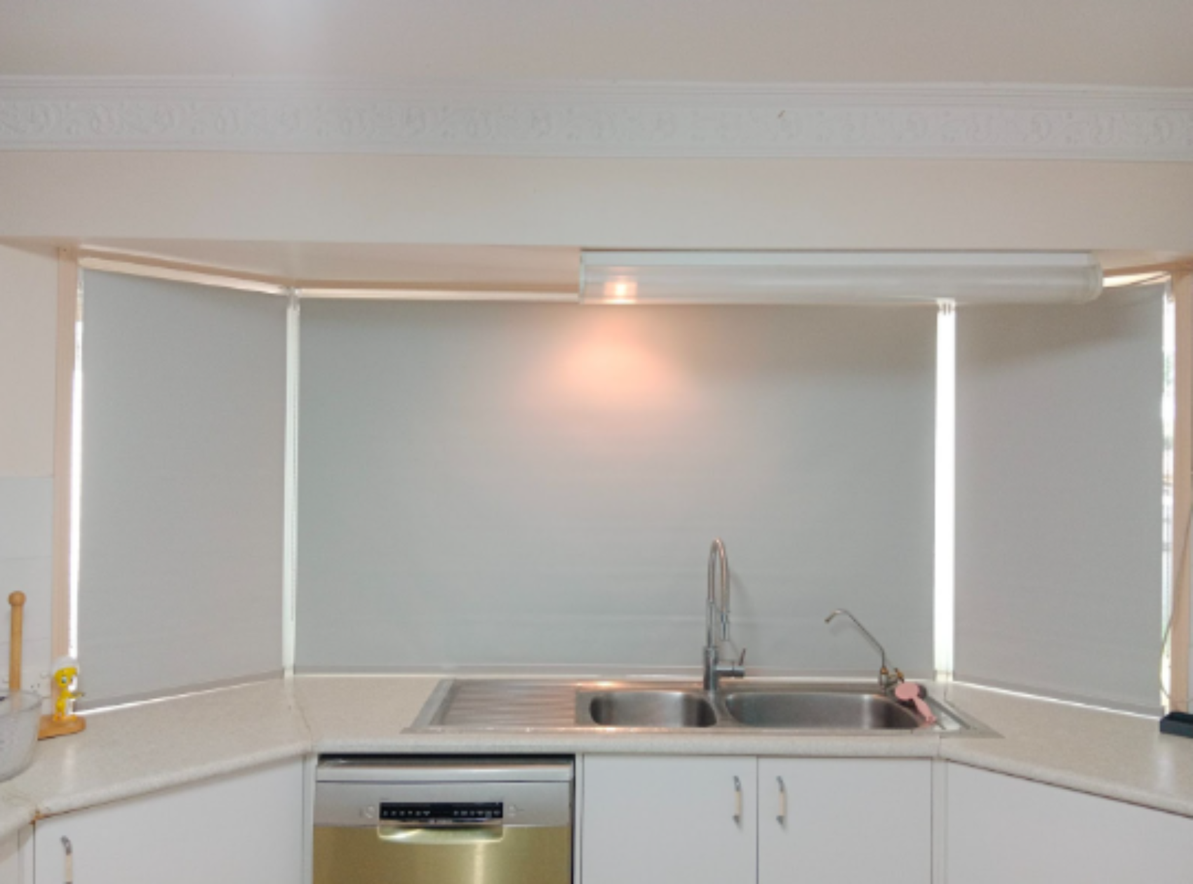 White blockout roller blinds installed on the kitchen bay windows