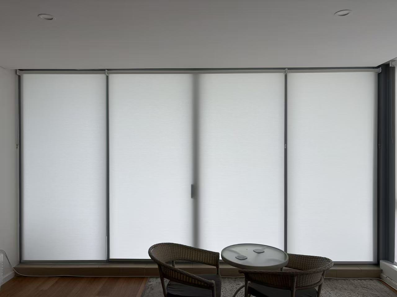 Three white light filtering privacy roller blinds installed for one window in dining area