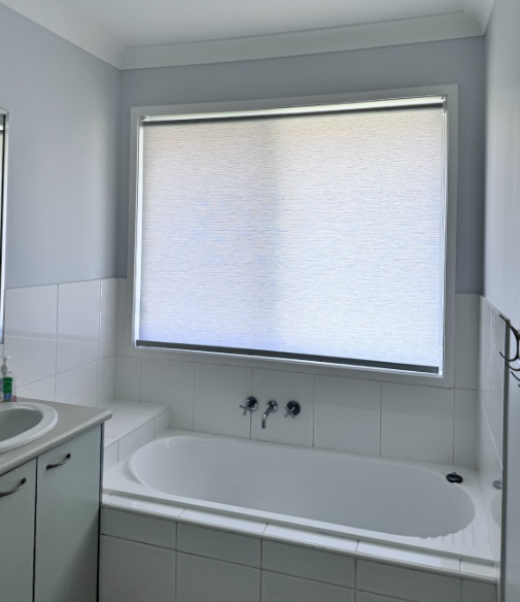 White light filtering privacy roller blind installed in bathroom