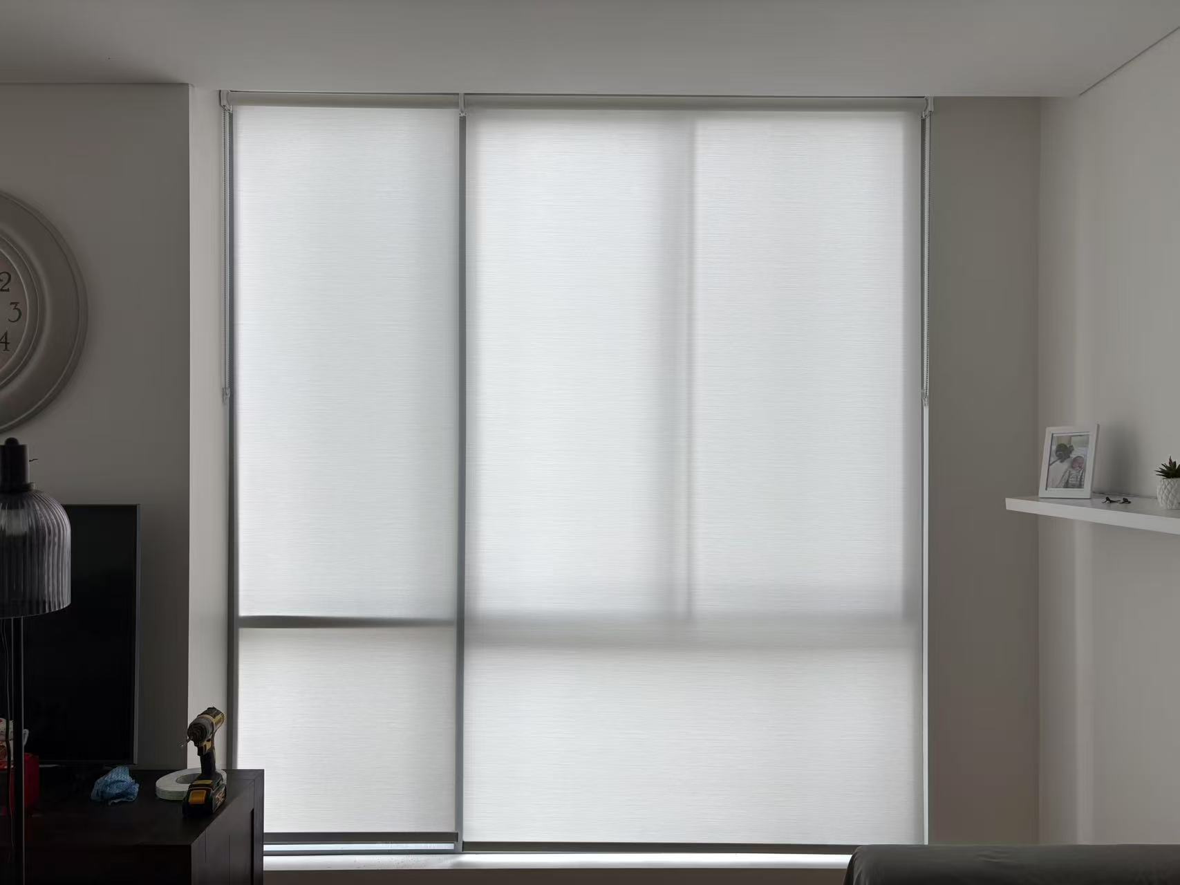 Two white light filtering roller blinds installed for one window