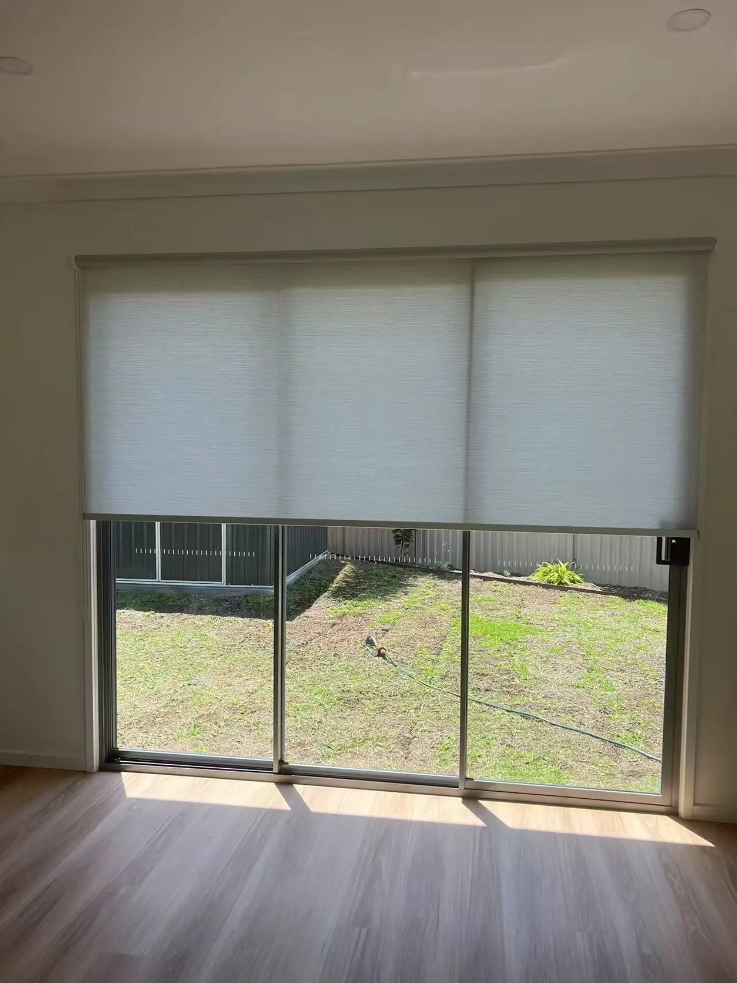 White light filtering privacy roller blinds installed for sliding foor