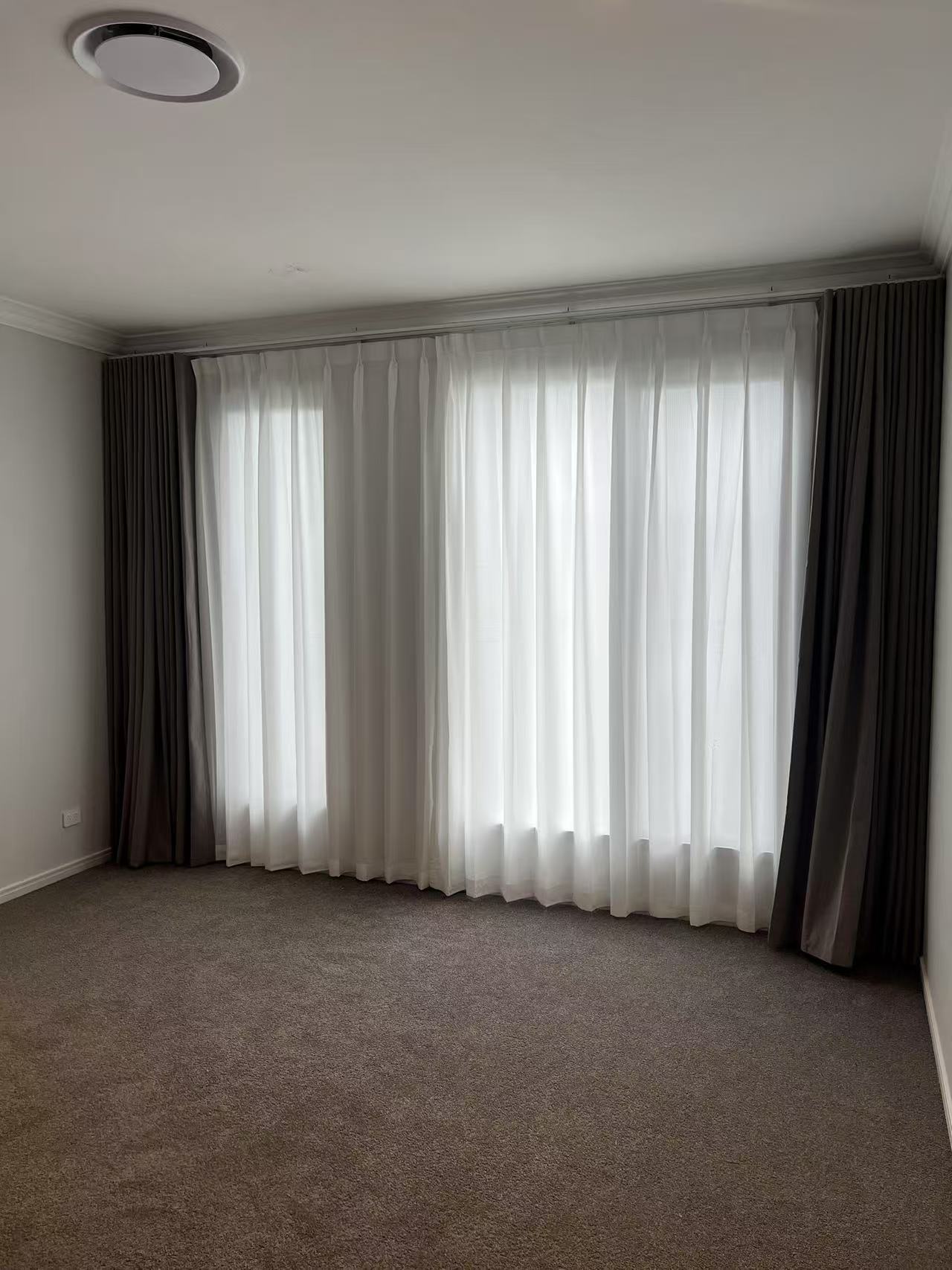 S-fold blockout curtain with pinch sheer installed for bedroom windows