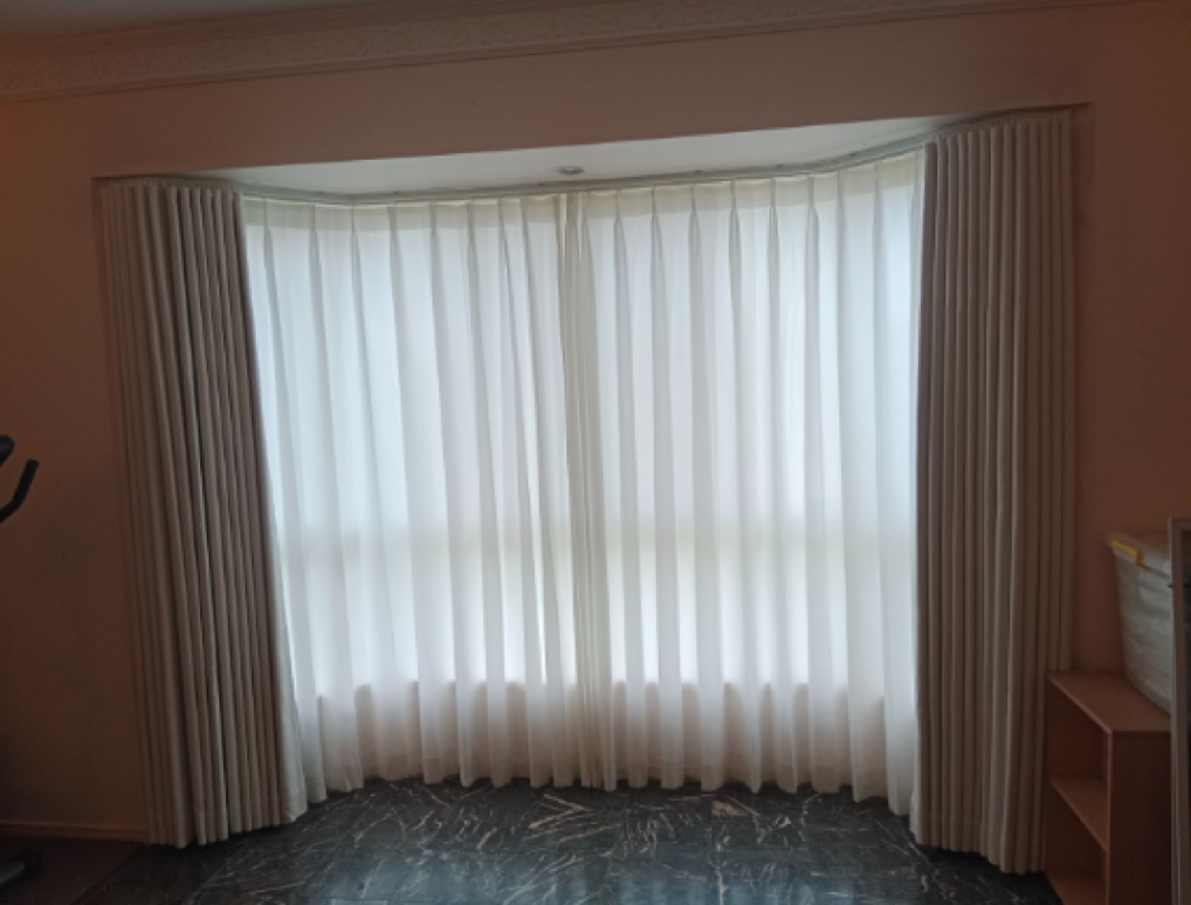S-fold blockout curtains and pinch privacy sheer installed for the bay windows