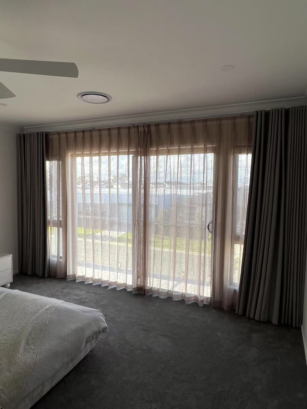 Brown S-fold blockout curtain and pinch transparent sheer installed in the master bedroom