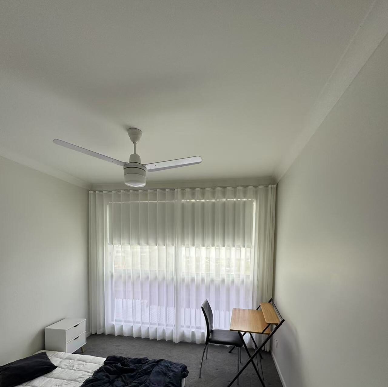 S-fold transparent sheer with grey blockout roller blind installed for bedroom window