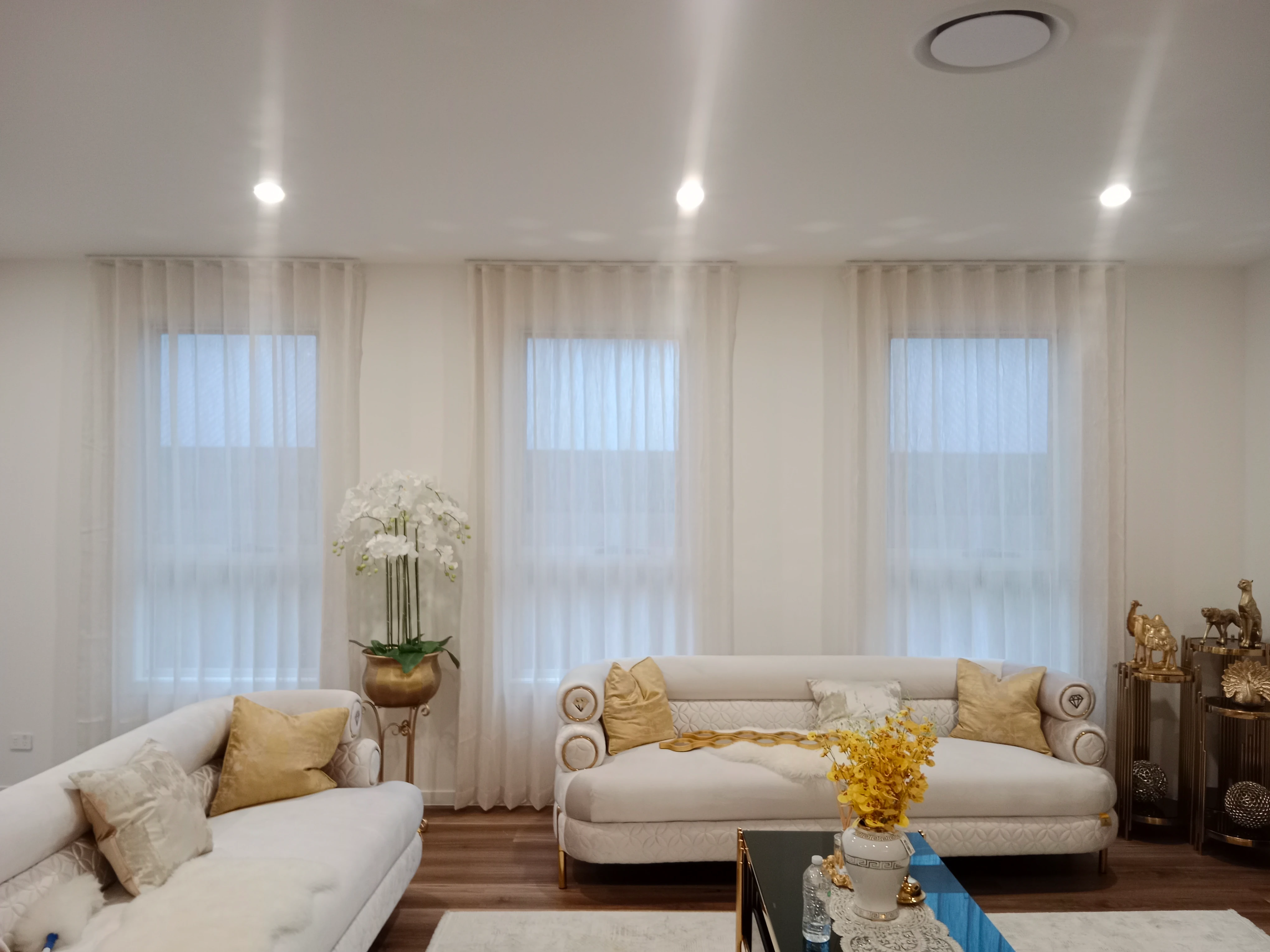 S-fold transparent sheers installed for three windows in living are