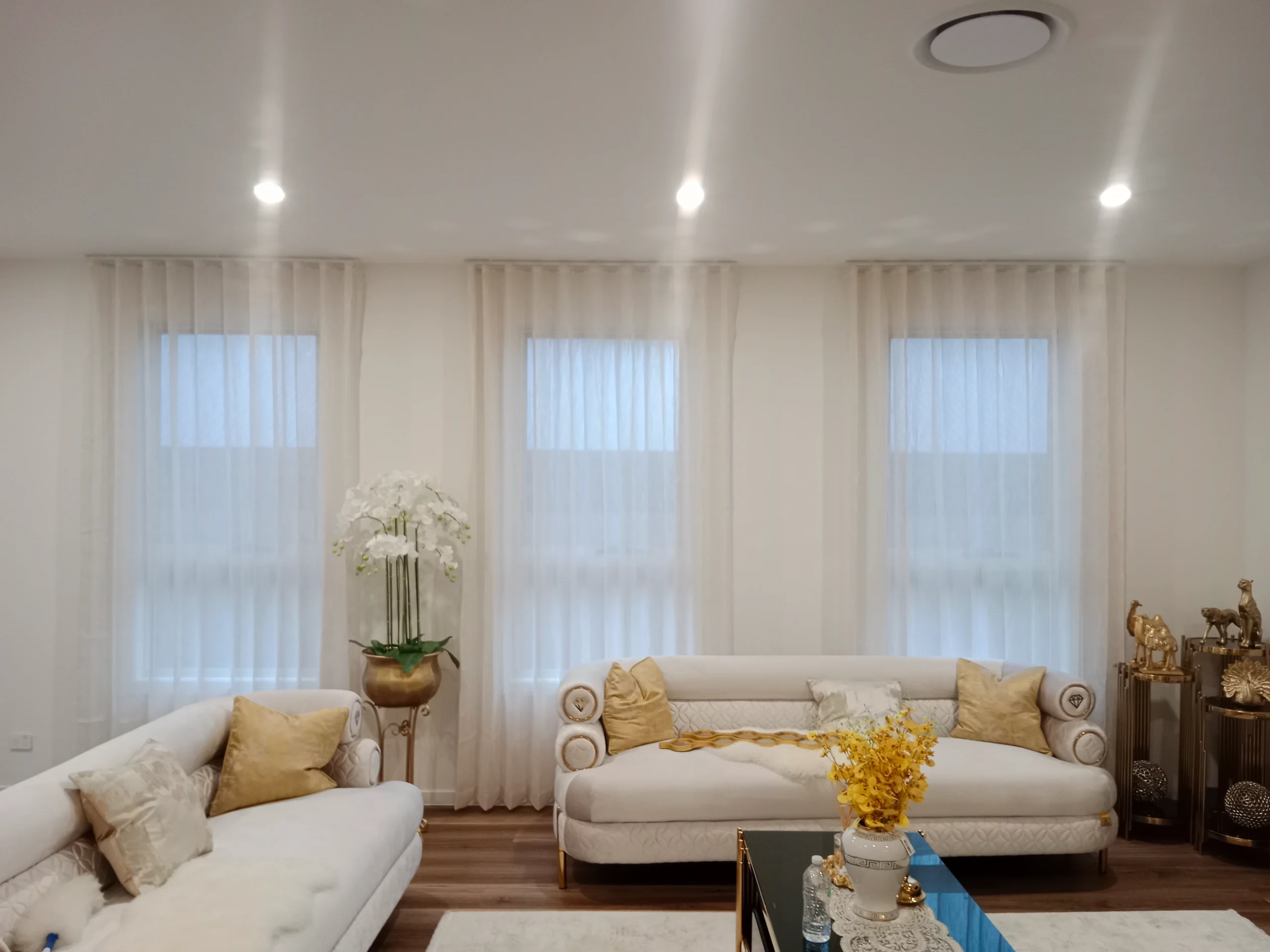 S-fold transparent sheers installed for three windows in living are scaled