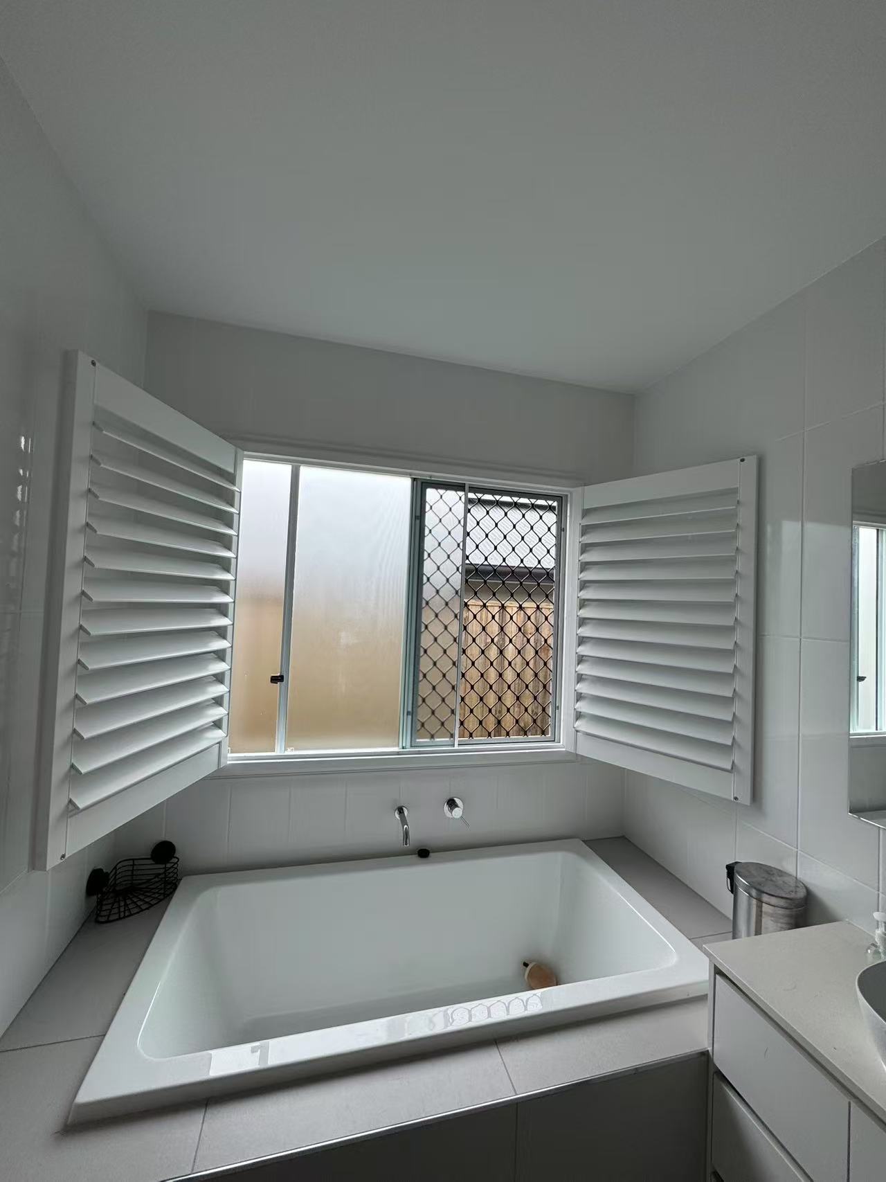 Planatation shutter installed for one widow with double open way in bathroom