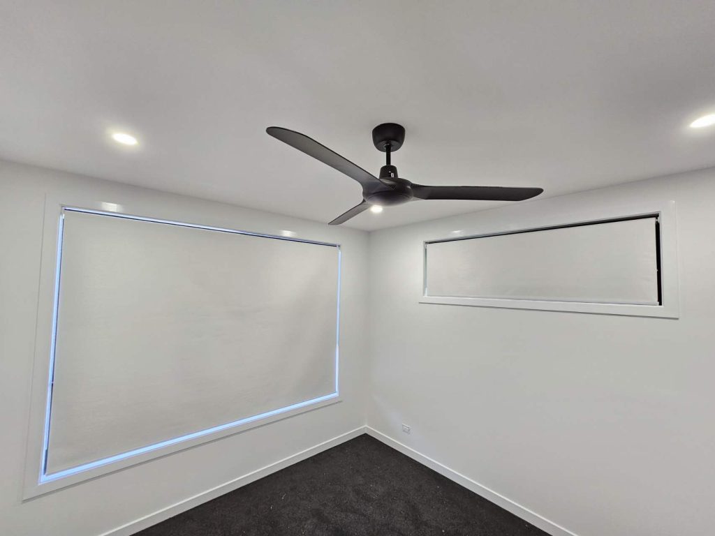 White blockout roller blind installed in a bedroom.