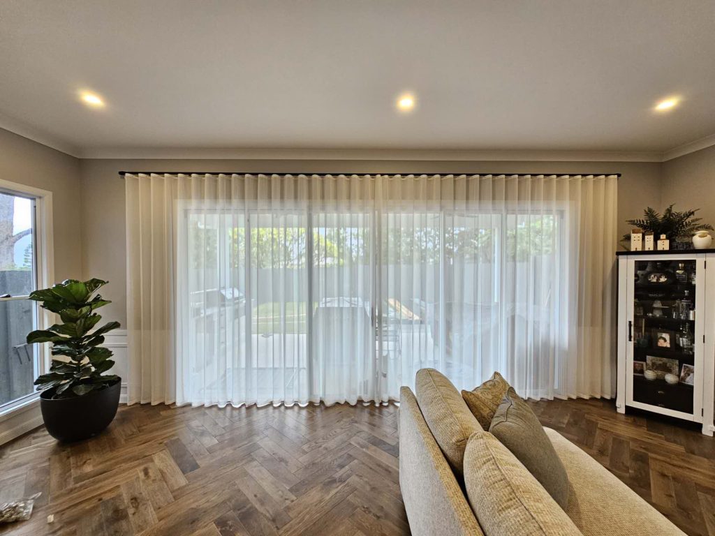 S-fold transparent sheers elegantly installed on a wide living room window.