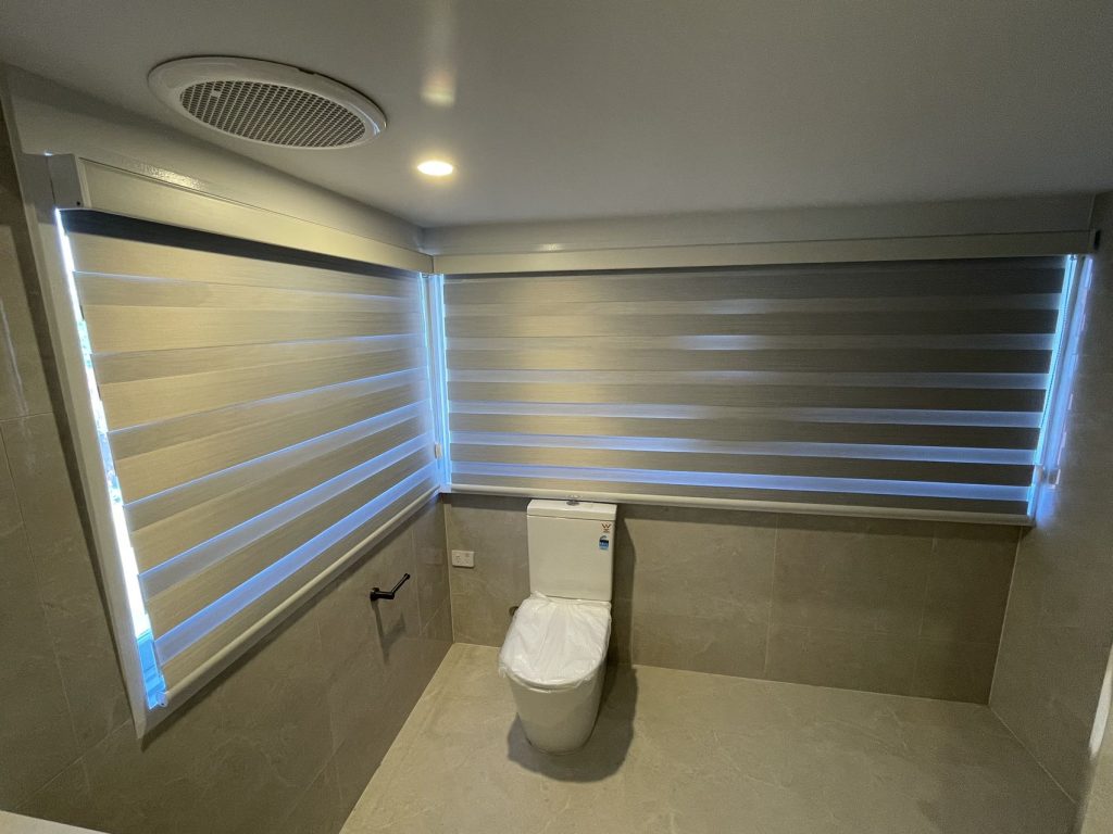 Zebra roller blinds installed in a bathroom by Bens Curtains.