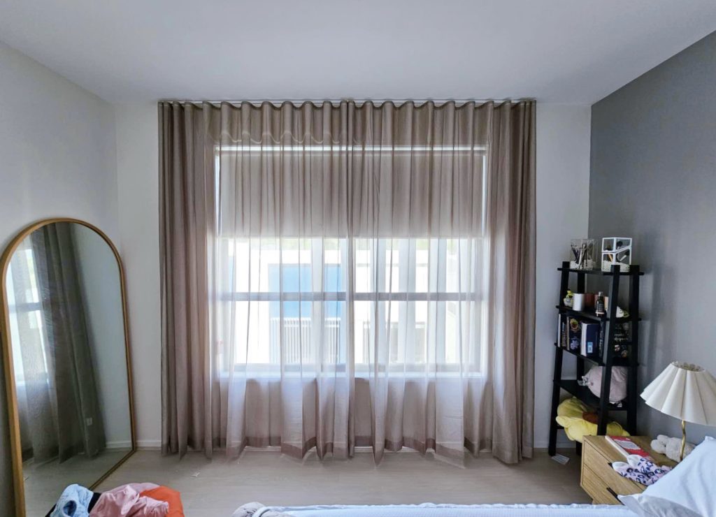 Brown S-fold transparent sheers elegantly installed in a bedroom.