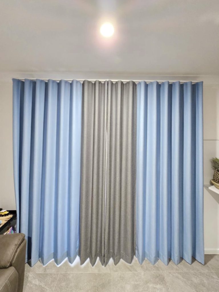 Blue and grey S-fold curtains hanging gracefully.