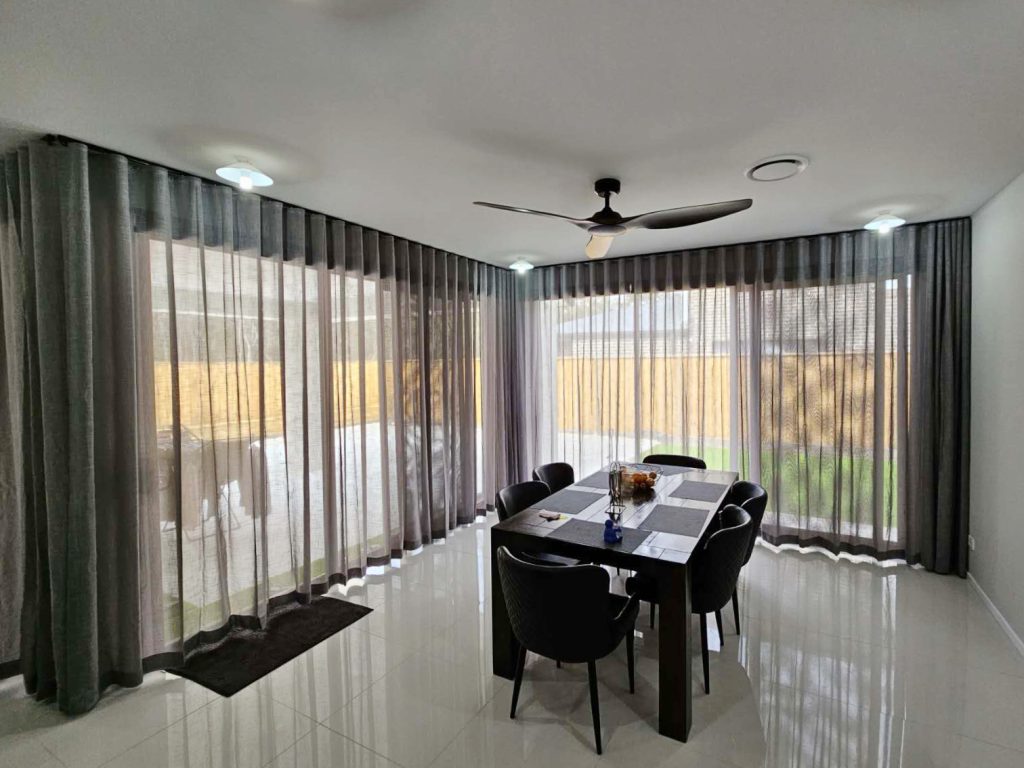 Dark grey S-fold transparent sheers elegantly installed in a dining room