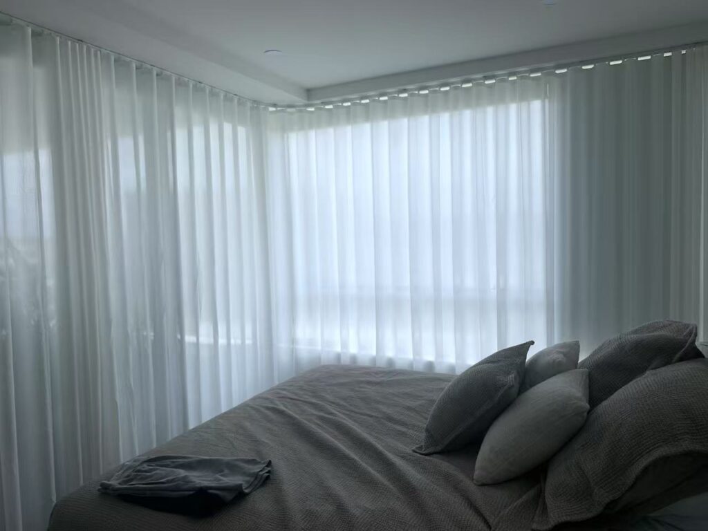 curved track s fold privacy sheer installed in a bedroom