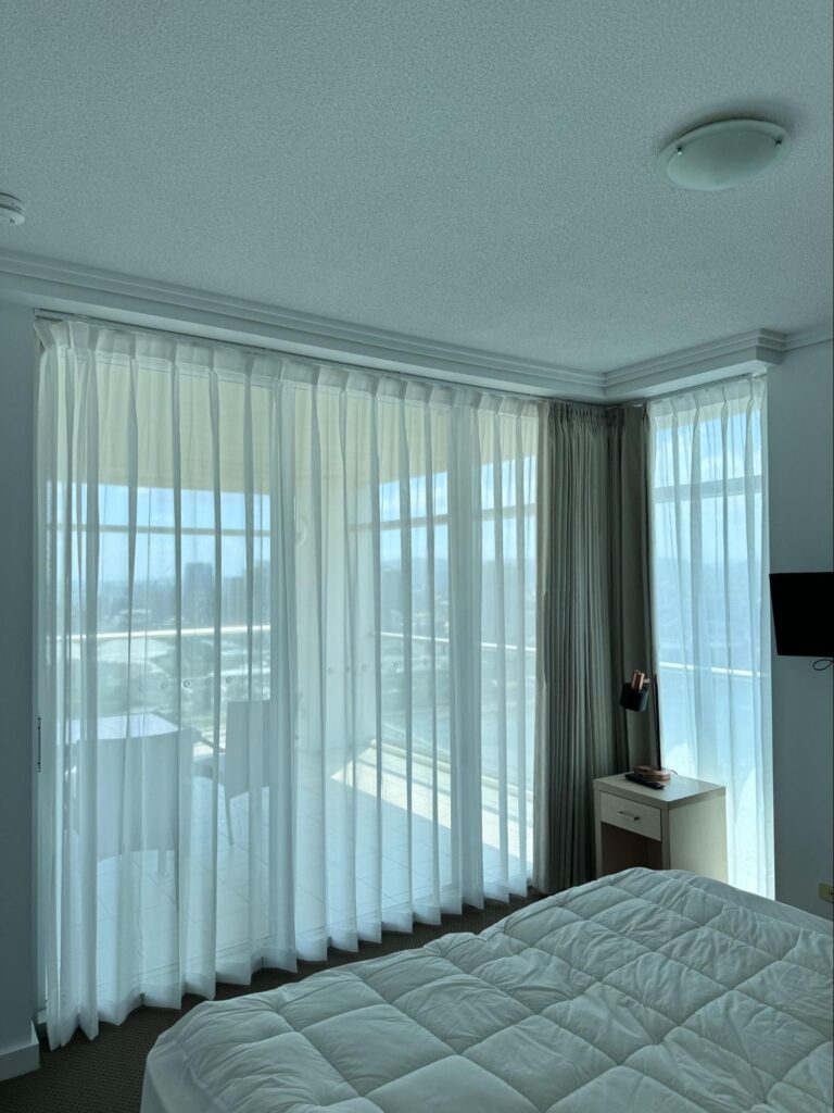 double tracks with pinch blockout curtain and pinch see through or transparency sheer installed in a bedroom