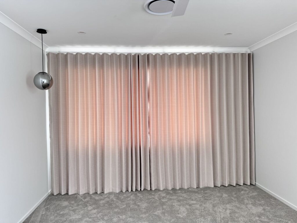 full wall mount semi cream or natural color blockout s fold curtains installed in a bedroom