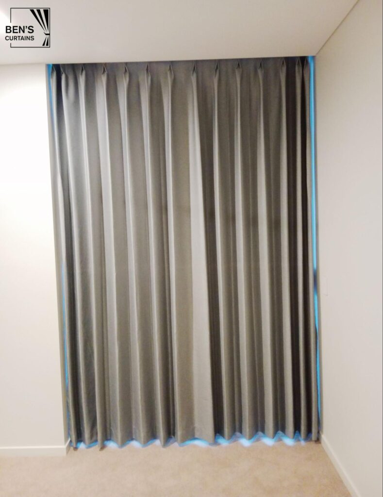 pinch 100% blockout grey curtain installed in a recessed curtain space