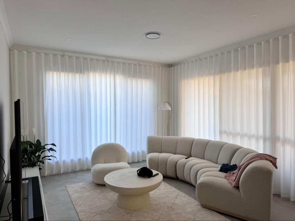 wall mount s fold privacy sheer installed on two sliding doors in a living room