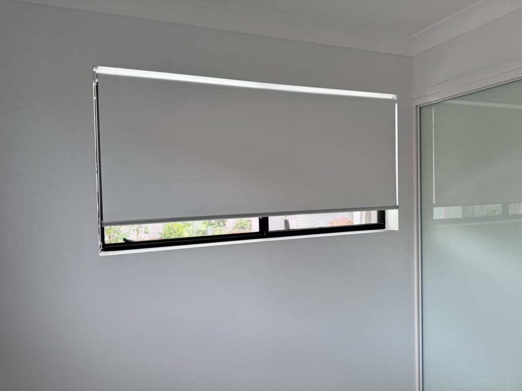 white blockout roller blinds installed within the window frame